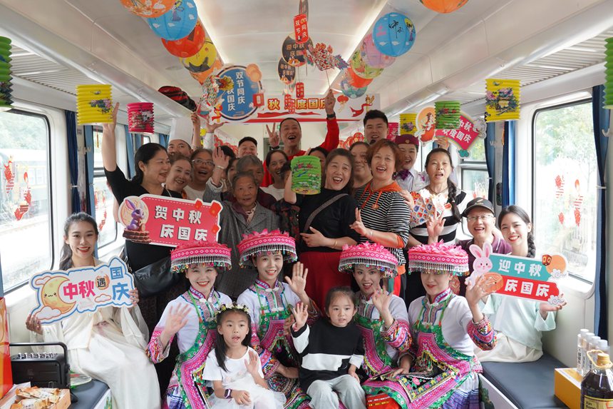 遵義開往重慶西的5630次列車上，旅客、演出人員、列車工作人員合影留念。李文航攝