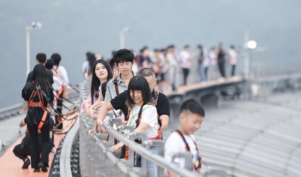 中秋國慶期間，游客正在體驗(yàn)重慶來福士探索艙·云端樂園“云中漫步”高空項(xiàng)目。受訪企業(yè)供圖
