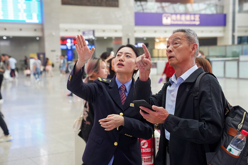 重慶北站，工作人員為旅客作引導(dǎo)。汪亮攝