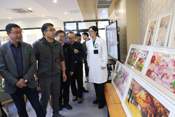 重慶市精神衛(wèi)生中心康復(fù)科主任袁媛向參觀者介紹患者作品。重慶市精神衛(wèi)生中心供圖