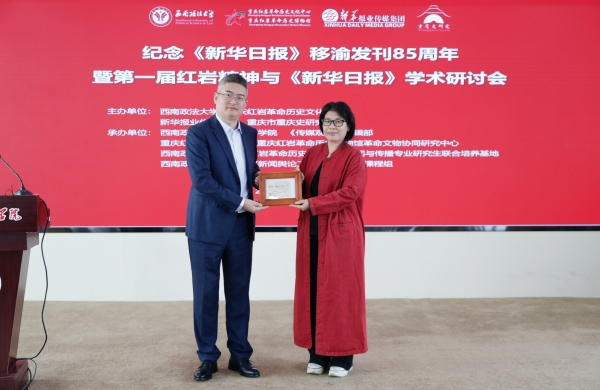 西南政法大學(xué)新聞傳播學(xué)院副院長蔡斐（左）向新華報(bào)業(yè)傳媒集團(tuán)《傳媒觀察》雜志贈送1952年《新華日報(bào)》訂報(bào)收據(jù)。西南政法大學(xué)供圖
