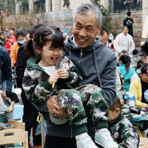 活動(dòng)現(xiàn)場一位爺爺抱起了孫女。新絲路幼兒園供圖