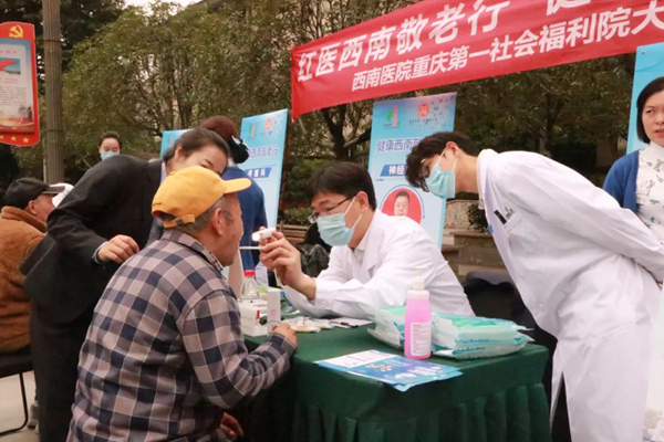 來自陸軍軍醫(yī)大學(xué)西南醫(yī)院的醫(yī)生們?yōu)樵簝?nèi)老人免費看診。重慶市第一社會福利院供圖