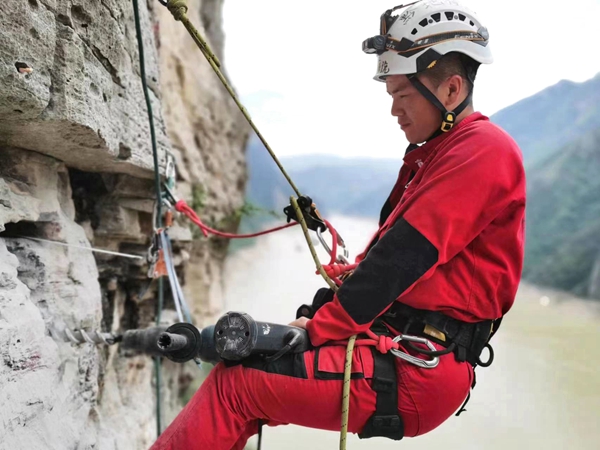 《懸崖鉆孔，安裝監(jiān)測設(shè)備》。7月下旬，重慶地質(zhì)礦產(chǎn)研究院派出的專業(yè)“蜘蛛人”開展高空作業(yè)，在奉節(jié)開展危巖隱患區(qū)域崖壁傳感器安裝工作，保障地質(zhì)安全。鄧朝松攝