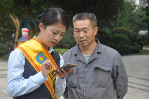 工作人員向居民講解“重慶渝快?！薄Ｖ貞c渝快保服務(wù)中心供圖