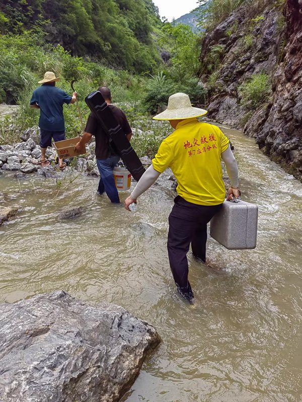 《跋山涉水  調(diào)查險(xiǎn)情》。7月上旬，重慶地質(zhì)礦產(chǎn)研究院駐守地質(zhì)工程師葉兆榮（右），攜帶地質(zhì)調(diào)查航拍設(shè)備，前往巫山縣兩坪鄉(xiāng)開展三峽庫(kù)區(qū)重大危巖崩塌隱患調(diào)查。鄧朝松攝