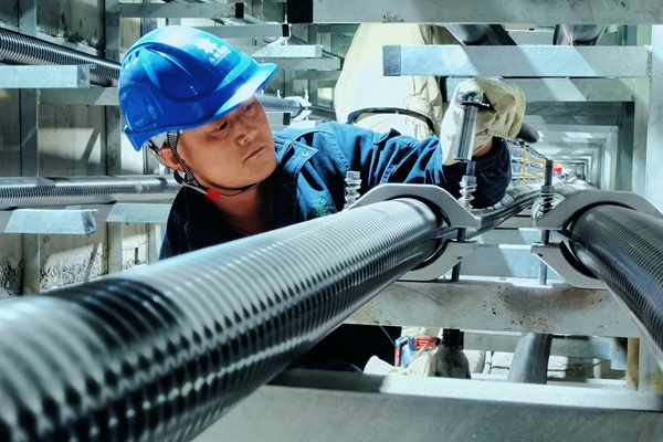 工作人員在安裝電纜抱箍。艾黎攝