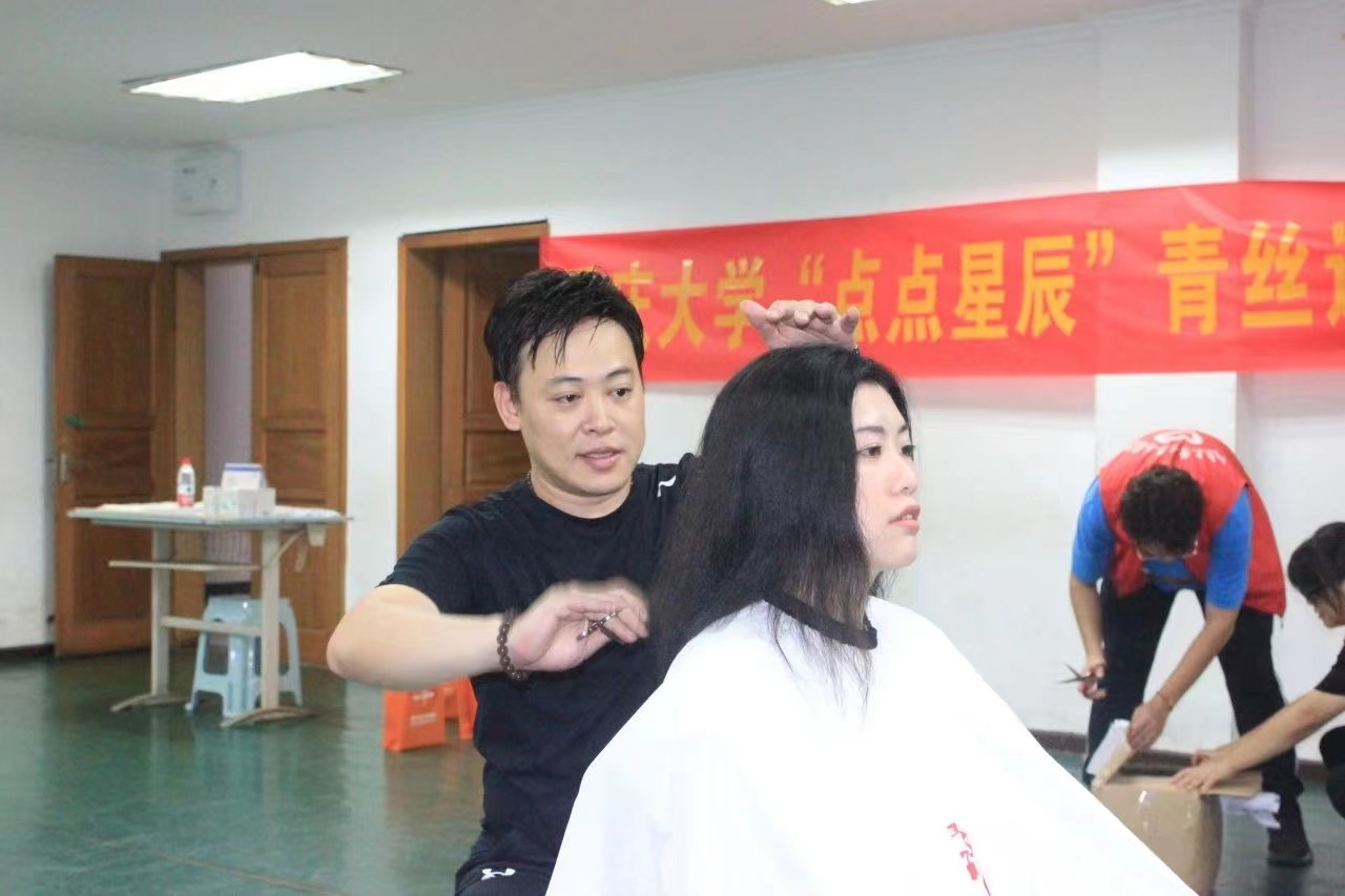 理發(fā)師為志愿者剪發(fā)。重慶大學(xué)供圖