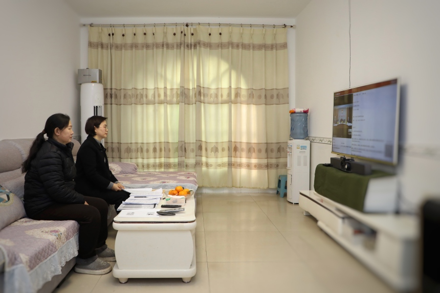 原告劉興容（左）在家中通過(guò)電視機(jī)“全渝數(shù)智法院TV版”出庭。蹇懿攝
