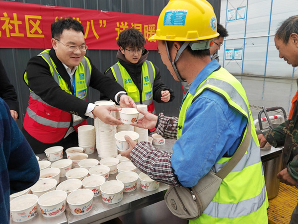 果園港國際樞紐經濟產業(yè)園二期項目，工人收到熱氣騰騰的臘八粥。中建八局供圖