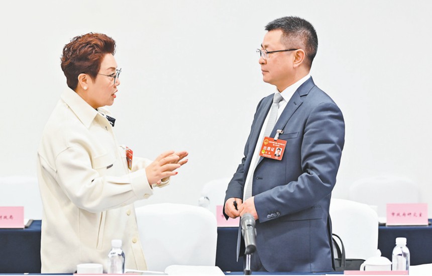 　1月22日，市人大代表在會(huì)議間隙就引進(jìn)AI機(jī)器人智能駕培系統(tǒng)的建議展開討論。記者 齊嵐森 攝/視覺重慶