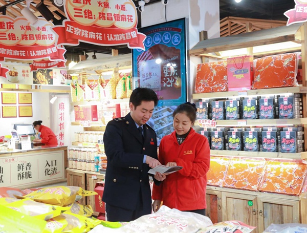 春節(jié)臨近，沙坪壩區(qū)稅務(wù)人員在陳麻花門店宣傳稅收優(yōu)惠政策。何獻(xiàn)攝