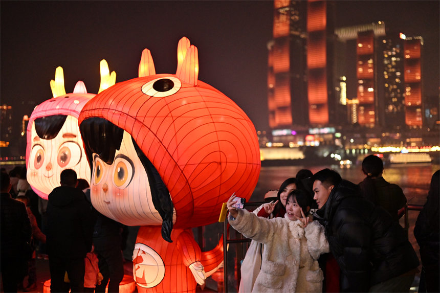2月9日除夕夜，南岸區(qū)南濱路，燈光秀與重慶夜景交相輝映，吸引眾多市民前來觀看。郭旭攝