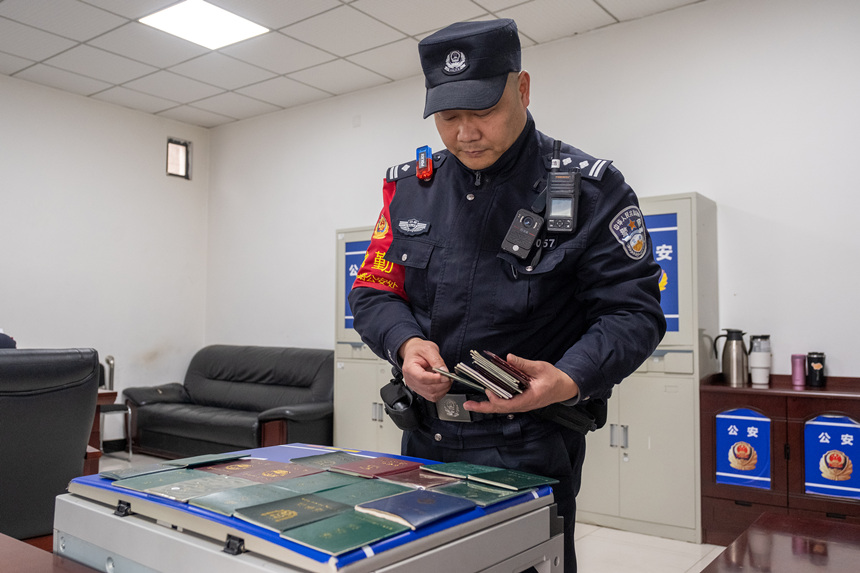 在重慶西車站派出所，牟浩對旅客遺失的證件進行整理。王新剛攝