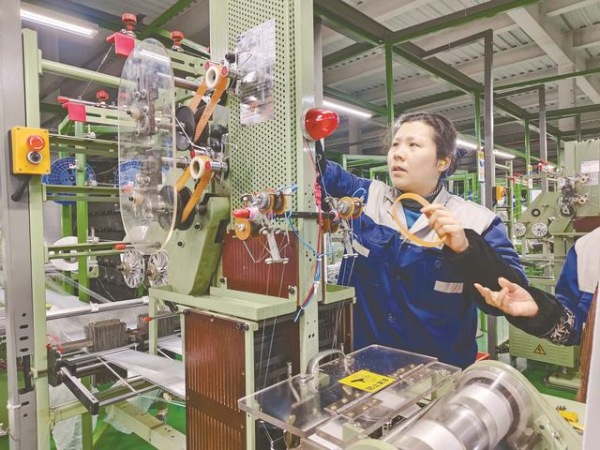 工人正熟練操作機械生產(chǎn)安全帶織帶。鄰水縣融媒體中心供圖