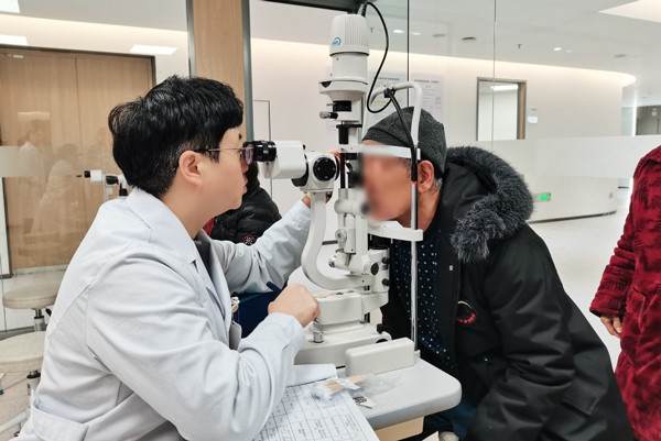 張曉城為患者檢查眼部情況。重慶南坪愛爾眼科醫(yī)院供圖