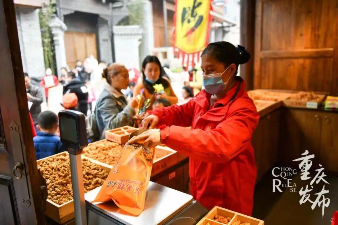 重慶磁器口古鎮(zhèn)后街，游客在選購陳麻花特產(chǎn)。鄒樂供圖
