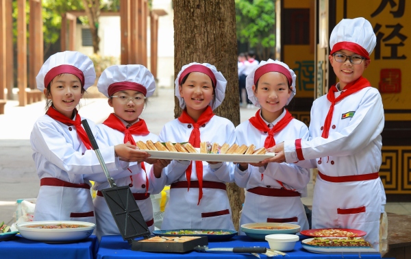 學生正在展示他們親手烹飪的美食。渝北區(qū)空港新城小學校供圖
