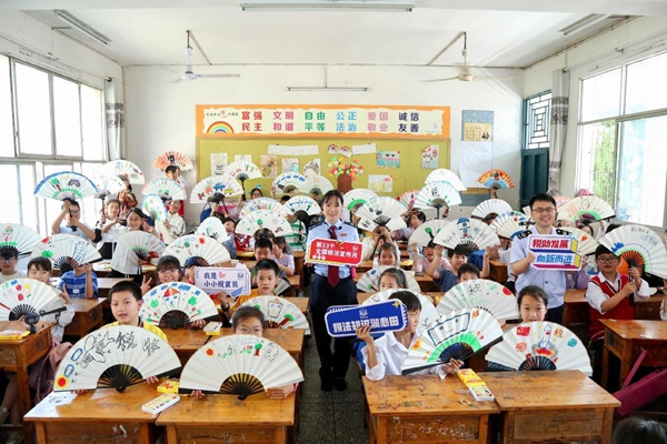 在開州區(qū)臨江鎮(zhèn)中心小學，同學們展示自己親手做的稅法主題手工折扇。趙詩琦攝