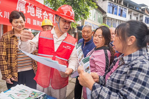 政、警、企相關(guān)人員向群眾發(fā)放宣傳手冊、介紹安全知識。國網(wǎng)重慶永川供電公司供圖