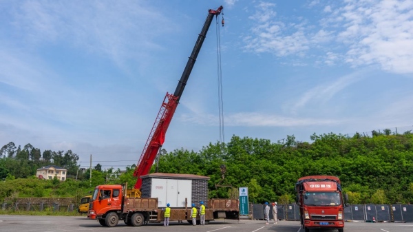 國網(wǎng)重慶電動汽車公司施工人員在對新建超充站的箱式變壓器進(jìn)行吊裝作業(yè)。國網(wǎng)重慶市電力公司供圖
