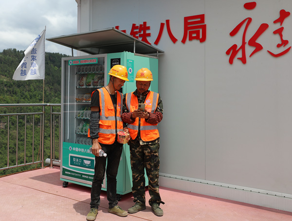 工友們正在安全知識(shí)競答自動(dòng)售賣機(jī)旁答題。中鐵八局供圖