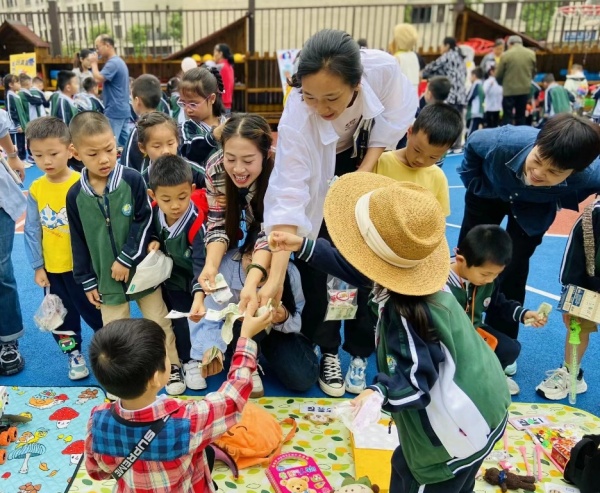 跳蚤市場上，小朋友們與家長一起買賣商品。北碚區(qū)椿山幼兒園供圖