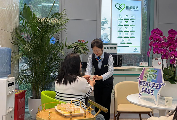 “郵愛(ài)驛站”工作人員為送考家長(zhǎng)端上熱水。郵儲(chǔ)銀行重慶分行供圖