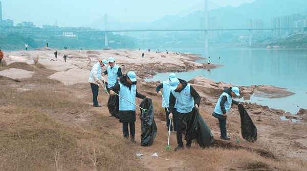 組織員工沿江岸撿拾垃圾。浦發(fā)銀行重慶分行供圖