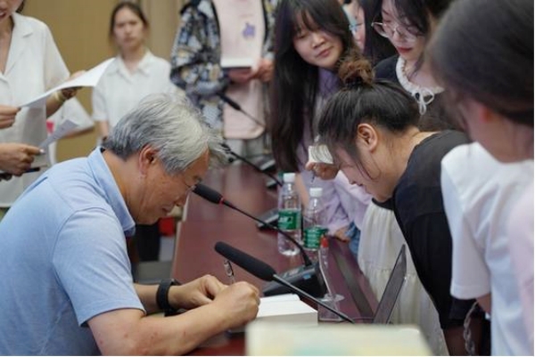 臧棣為師生簽名。重慶人文科技學院供圖