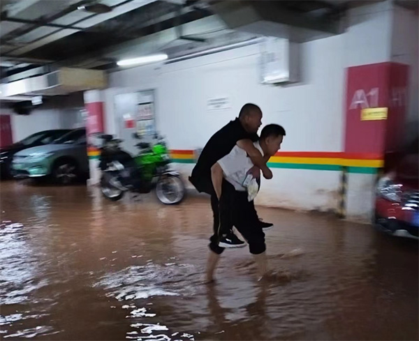 物業(yè)人員背著業(yè)主淌水至干凈區(qū)域。東原仁知物業(yè)供圖