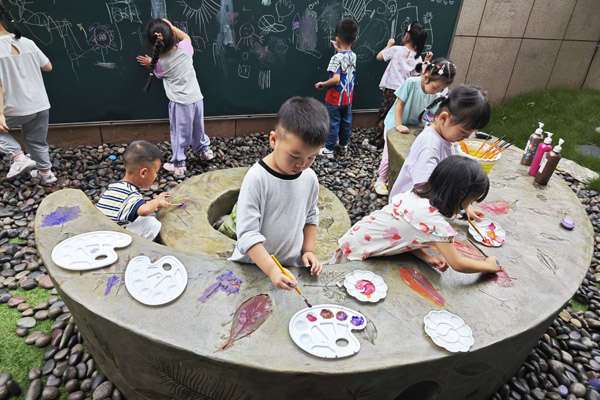 孩子們創(chuàng)作樹葉拓印水泥桌現(xiàn)場。二師附二幼供圖