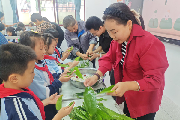 學生同家長、老師一起參加端午節(jié)包粽子傳統(tǒng)文化活動。雙福六小供圖