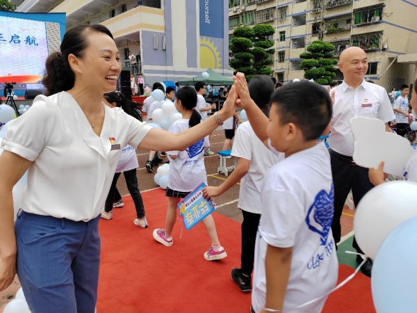 畢業(yè)禮上，黨員教師和孩子們擊掌。豐都縣濱江小學(xué)校供圖