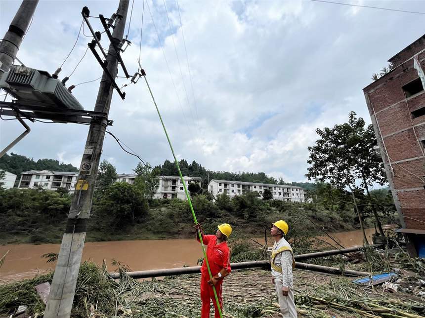 國網(wǎng)重慶豐都供電公司社壇供電所工作人員在洪水退去后恢復電力設施供電。劉遠平攝