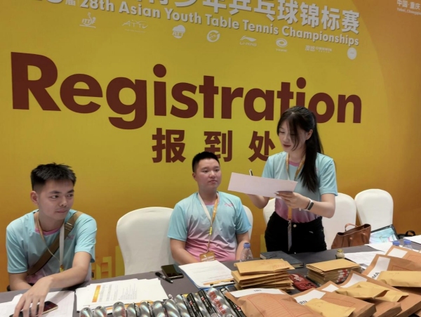 胡馨文（右一）在報到處等待運動員報到。向詩佳攝