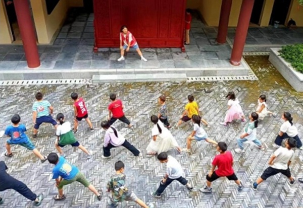 實踐隊隊員帶領(lǐng)留守兒童做熱身運動。重慶旅游職業(yè)學院供圖