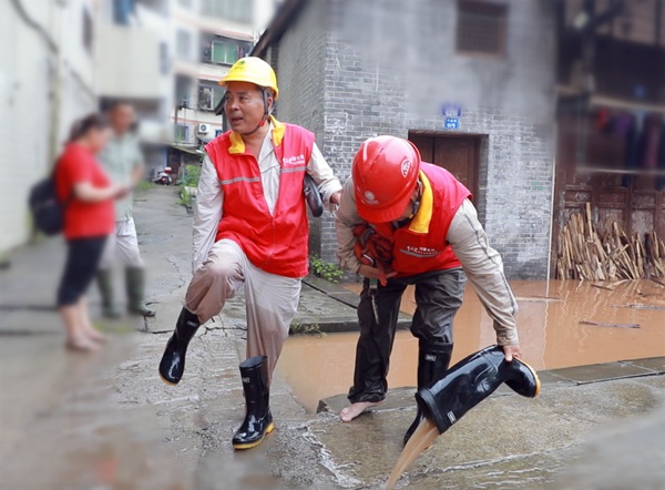 國家電網(wǎng)紅巖（榮昌）共產(chǎn)黨員服務(wù)隊隊員相互攙扶倒掉雨鞋里的水。國網(wǎng)重慶永川供電公司供圖