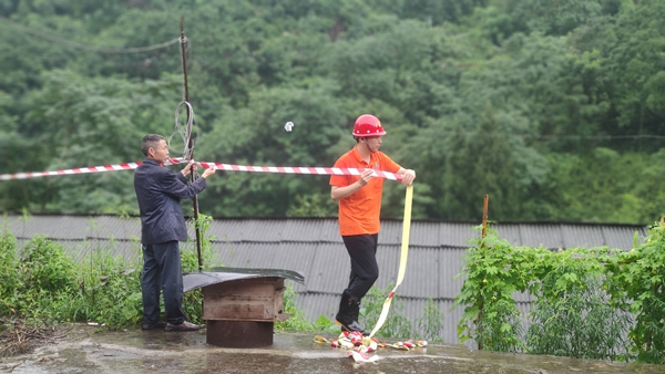 《警戒》。6月28日，綦江區(qū)石壕鎮(zhèn)一處斜坡突發(fā)滑坡險情，重慶一三六地質(zhì)隊地災駐守工程師鄧森木（右）配合當?shù)卣ぷ魅藛T在現(xiàn)場處置，設置警戒范圍。杜健攝