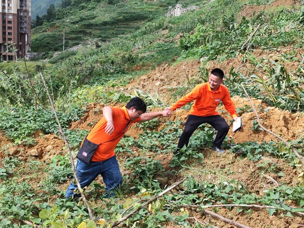 《跋涉》。6月29日，107地質(zhì)隊(duì)的駐守地質(zhì)工程師陳虹洲在彭水巡查雨后的地災(zāi)點(diǎn)時(shí)深陷泥潭，同事王發(fā)英搭手拽他脫離“困境”。李明亮攝