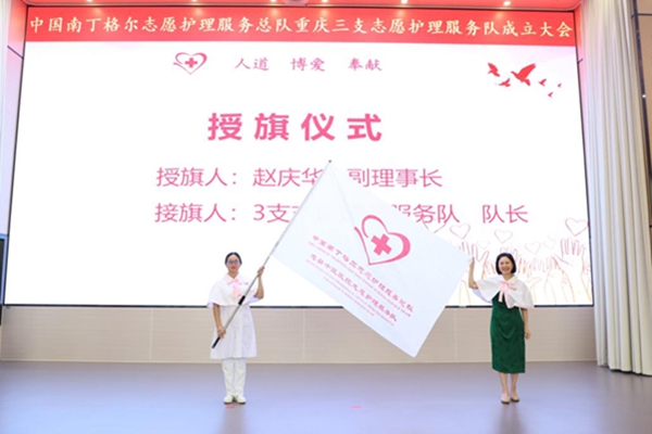 中國南丁格爾志愿護(hù)理服務(wù)總隊副理事長趙慶華（右）為服務(wù)隊授旗。李道國攝