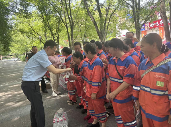 工作人員將清涼飲品送到環(huán)衛(wèi)工人手中。人保財(cái)險(xiǎn)重慶分公司供圖