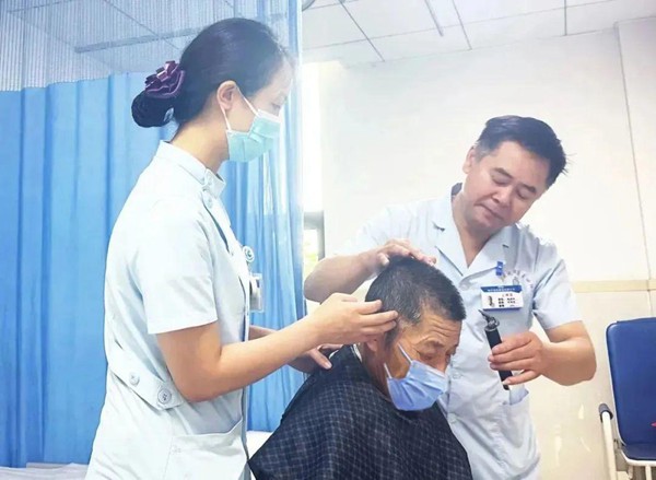 醫(yī)護為老年患者理發(fā)。重慶合川宏仁醫(yī)院供圖