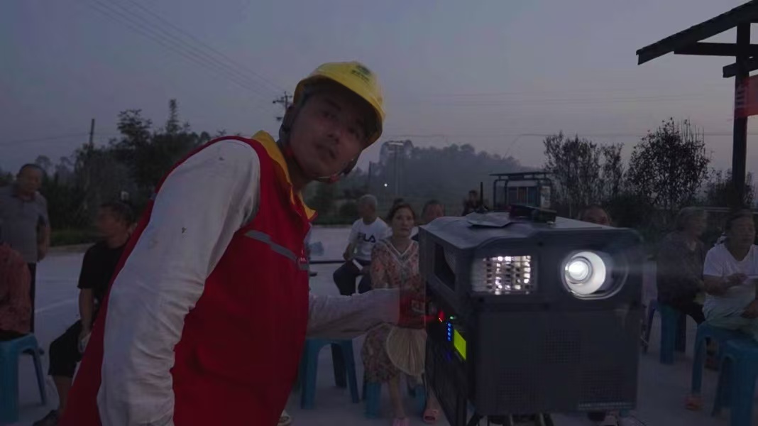 電力員工調(diào)試露天影院播放設(shè)施。國(guó)網(wǎng)重慶永川供電公司供圖