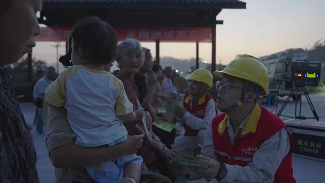 電力員工向村民發(fā)放節(jié)能宣傳資料。國(guó)網(wǎng)重慶永川供電公司供圖