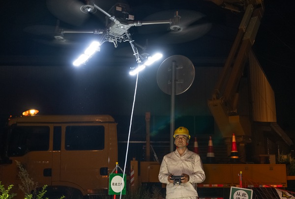 工作人員操作無人機配燈為不停電作業(yè)照明。國網重慶永川供電公司供圖