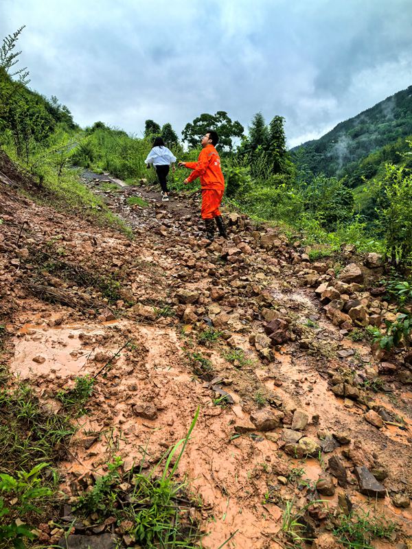 《雨后地災(zāi)巡查》。7月11日，巫山縣銅鼓鎮(zhèn)副鎮(zhèn)長溫利華、地質(zhì)駐守工程師王忠凌（右）雨后巡查銅鼓村柏果樹坪地災(zāi)點(diǎn)。劉勇攝