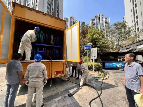 應急發(fā)電車正在鋪設電纜，準備應急發(fā)電給小區(qū)居民。顏非亞攝