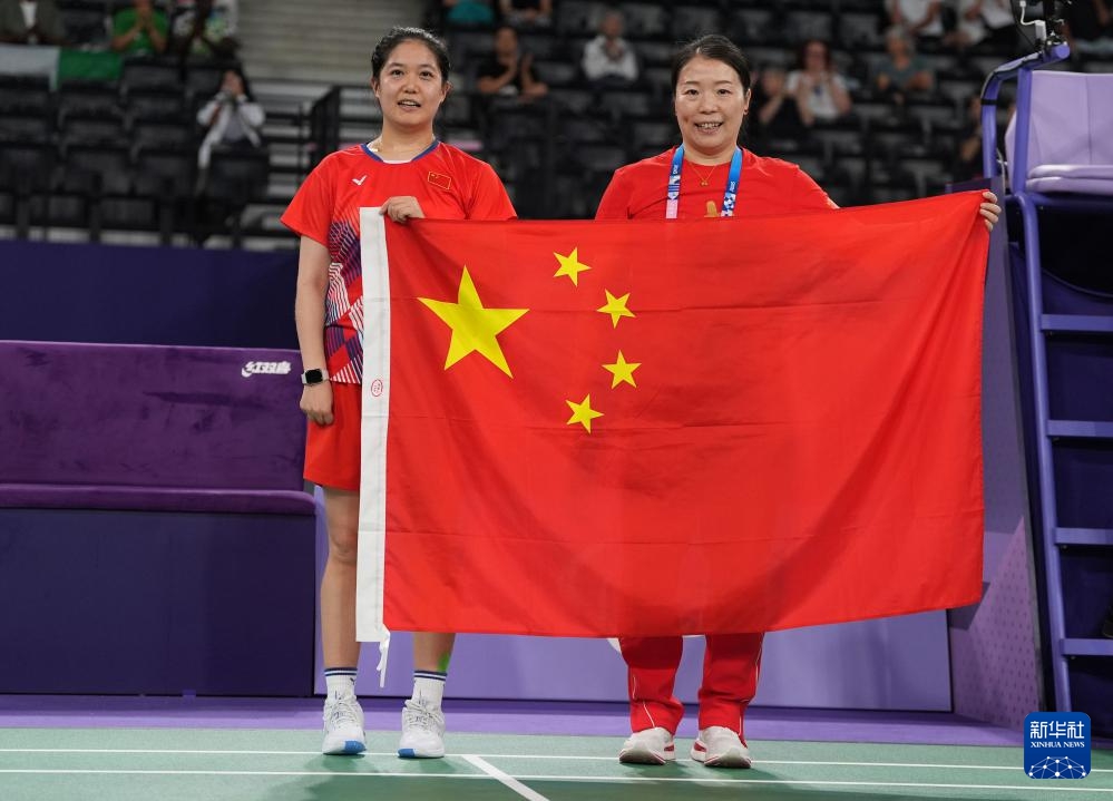 9月2日，肖祖賢（左）和教練張先明賽后慶祝勝利。新華社記者 邢廣利 攝