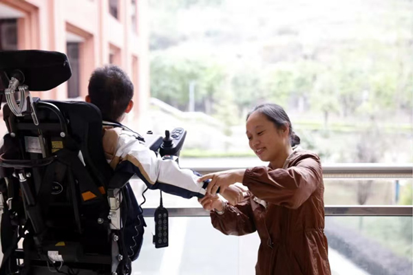 周朝喜給孩子整理衣袖。吳文藝攝